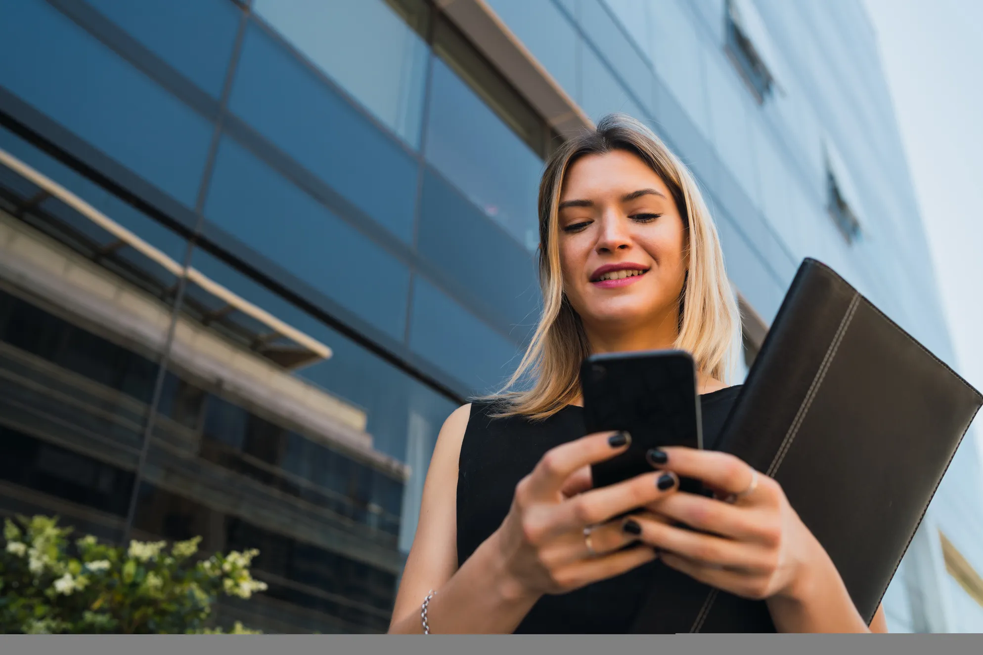 Mujer exitosa cerrando un negocio desde su dispositivo.